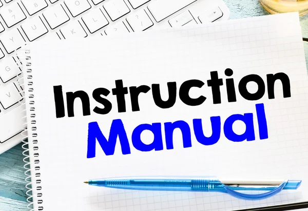 Egy jegyzetfüzet, amelyen az 'Instruction Manual' felirat olvasható, kék tollal.